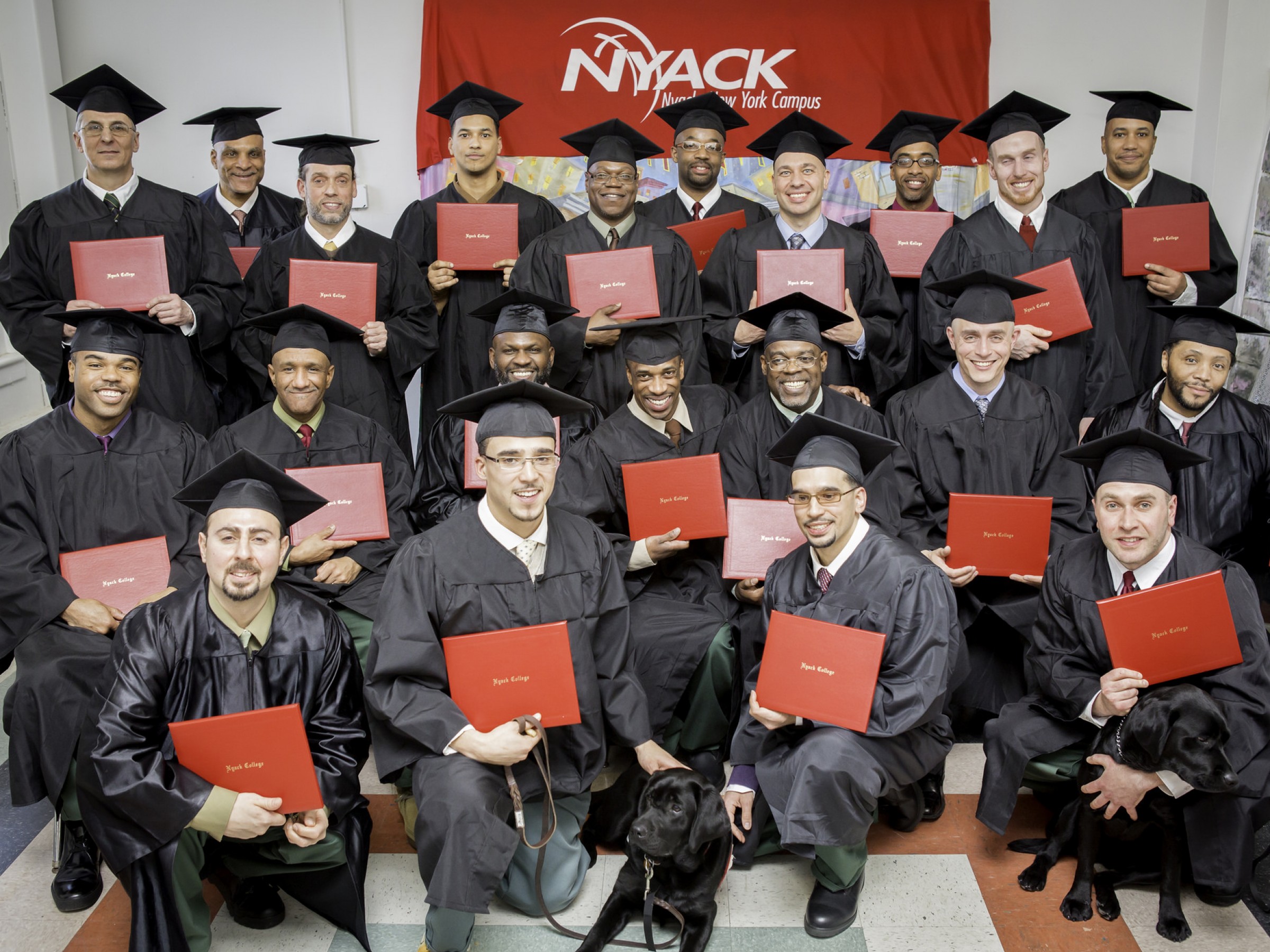 Hudson Link graduates pose for a group photos with their diplomas