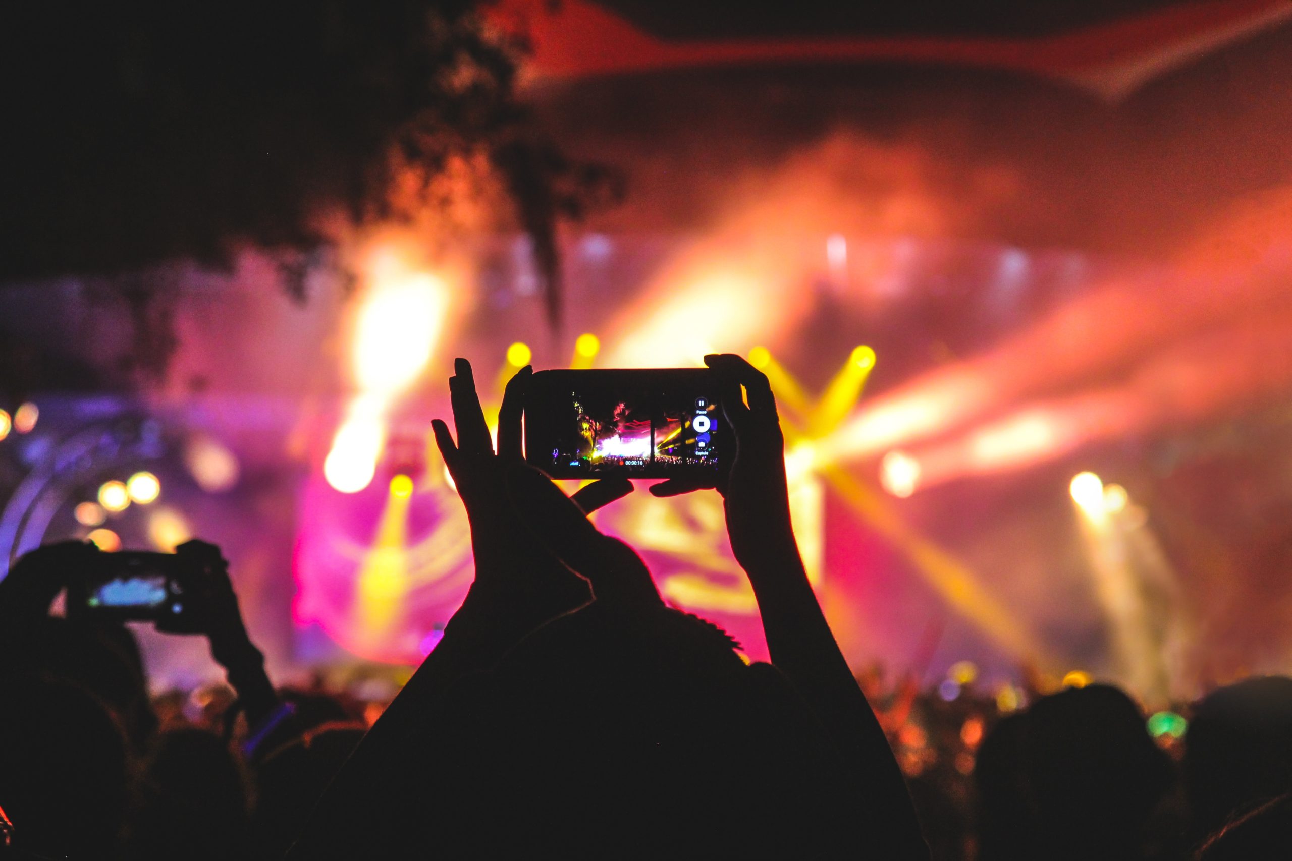 A person takes a video at a concert