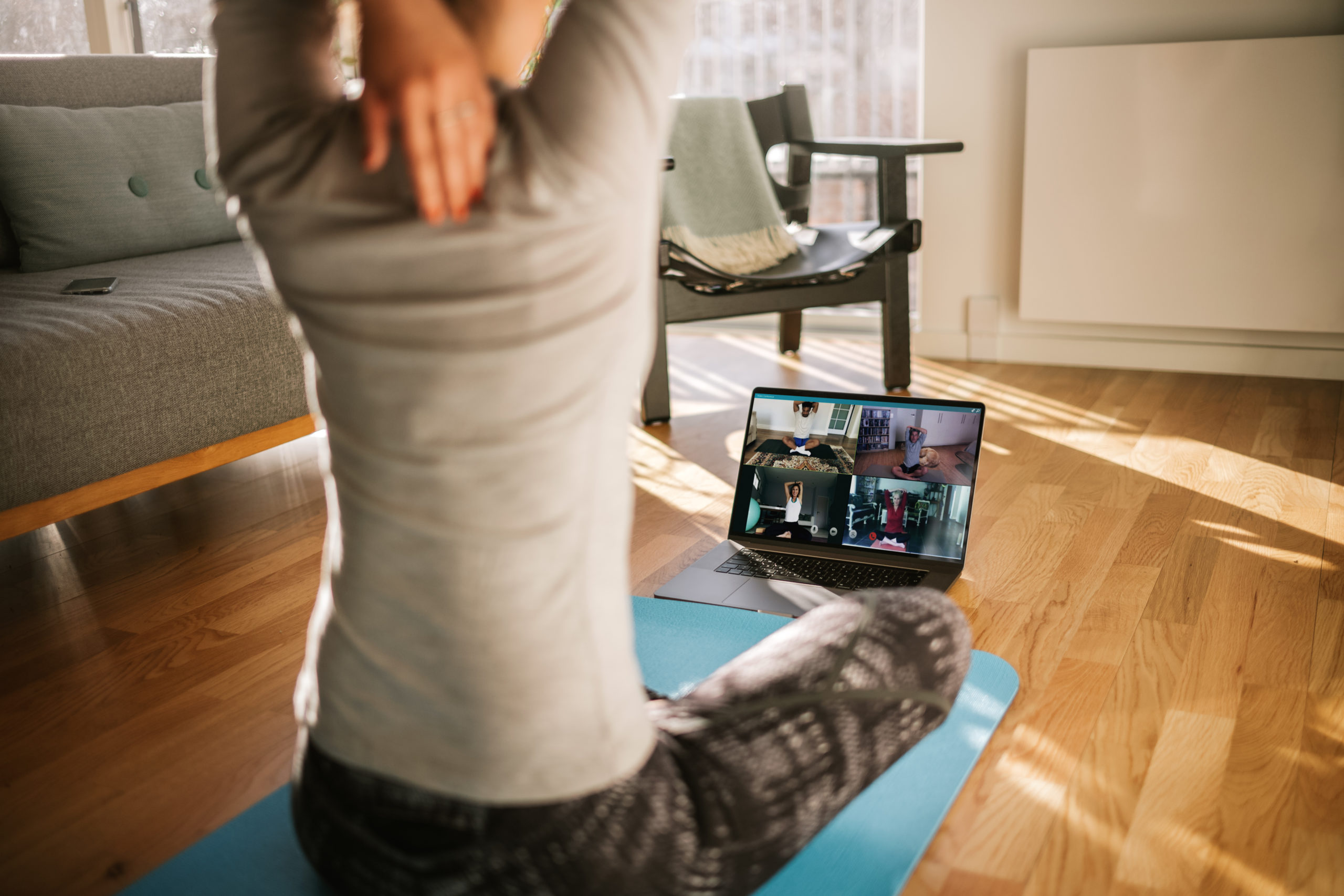 A woman stretches during a virtual yoga session