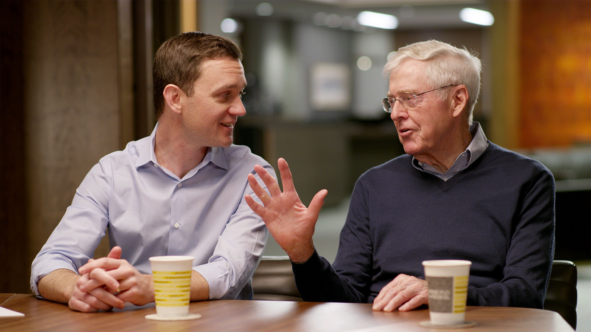 Charles Koch and Brian Hooks at a table talking