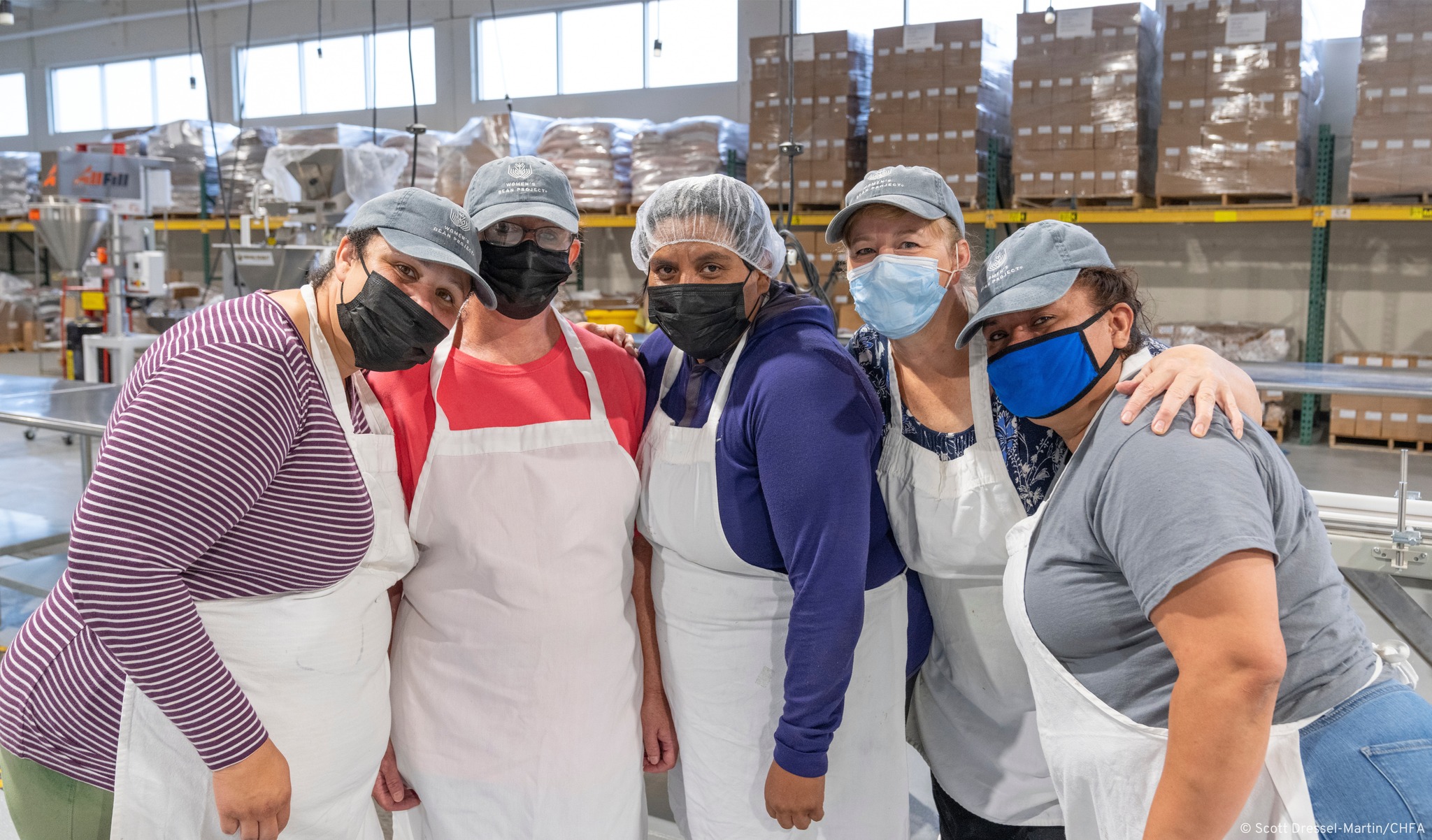 Women's Bean Project workers pose for a photo in the packing facility
