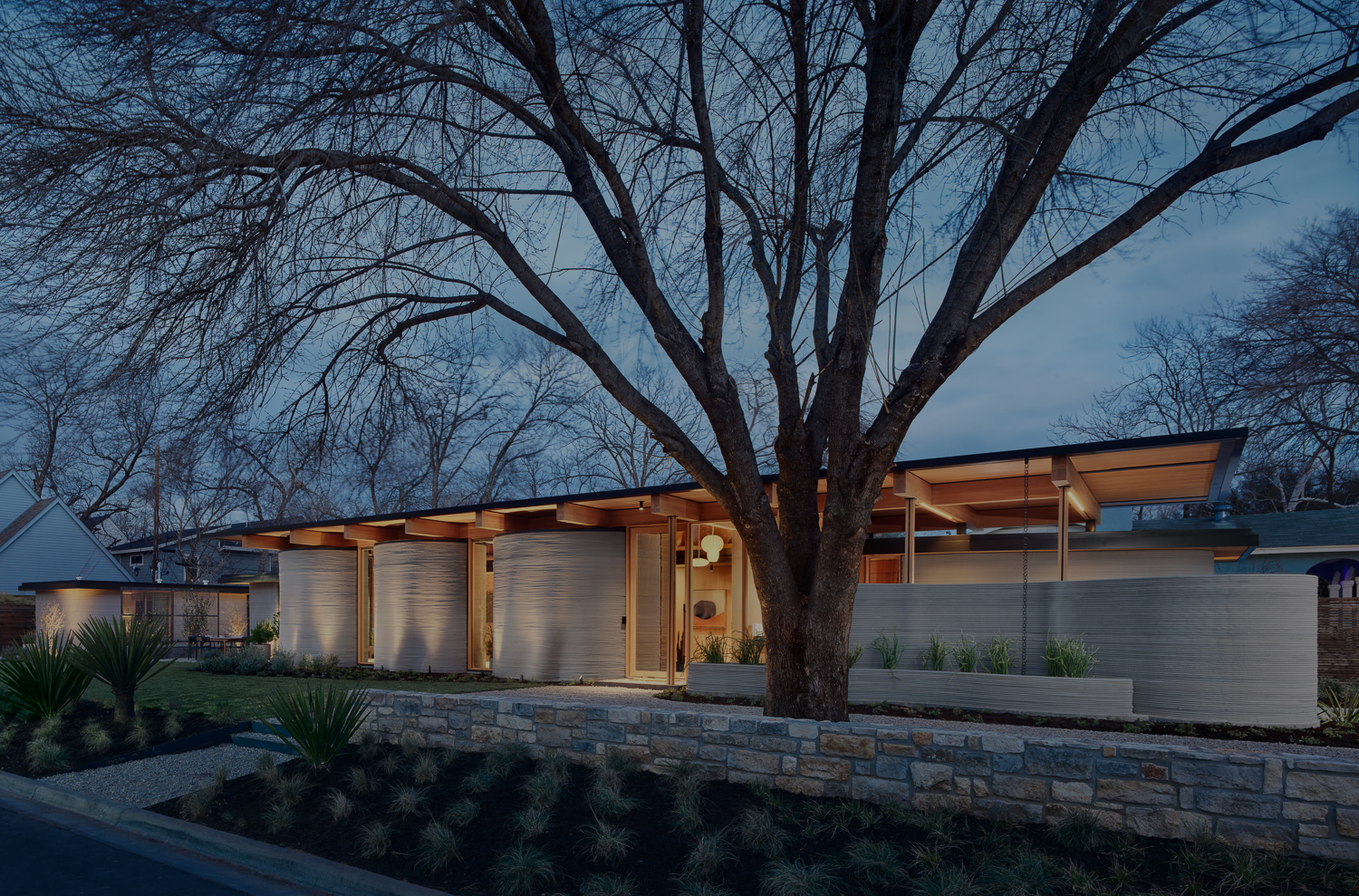 A beautifully illuminated modern house at dusk.