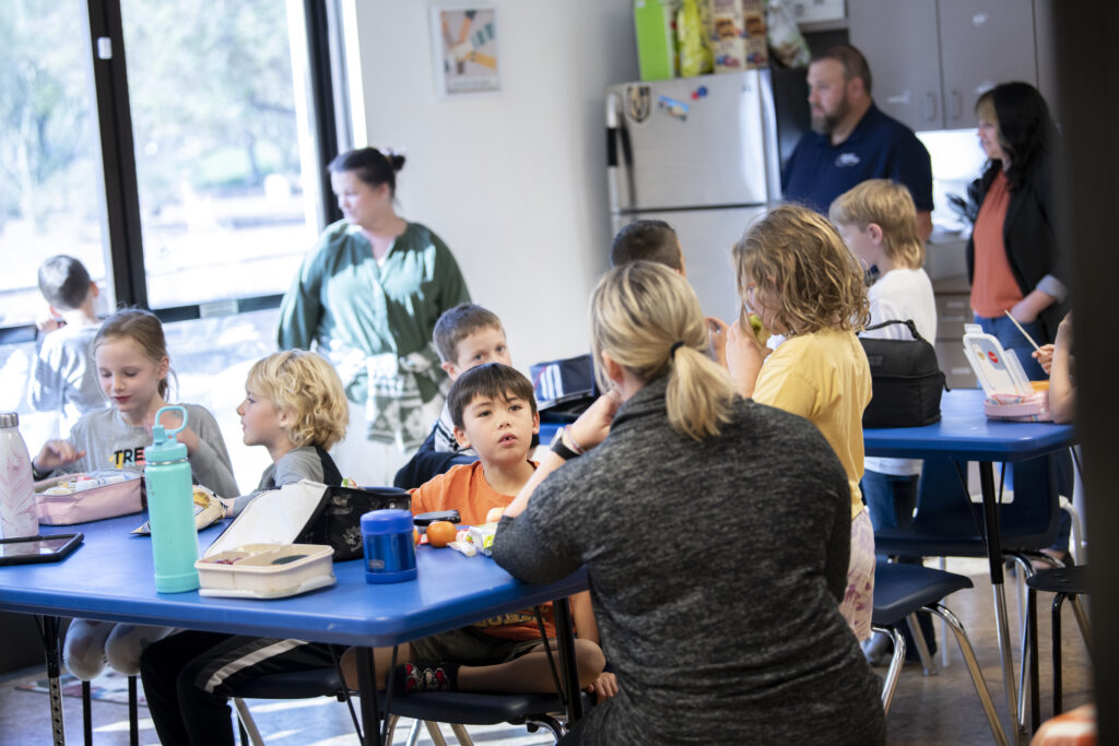 Parents sitting down with children in the classroom, showing the importance of family engagement in schools.