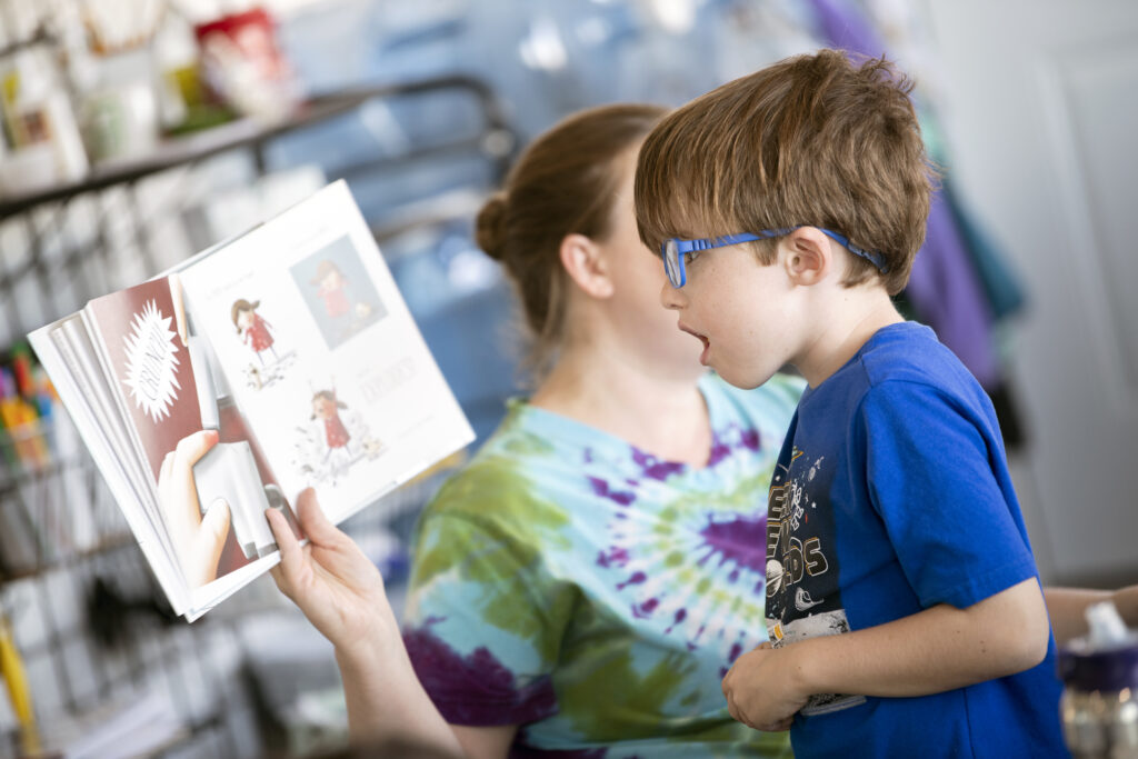 Boy reading a book with a family member showing why family engagement in schools is important